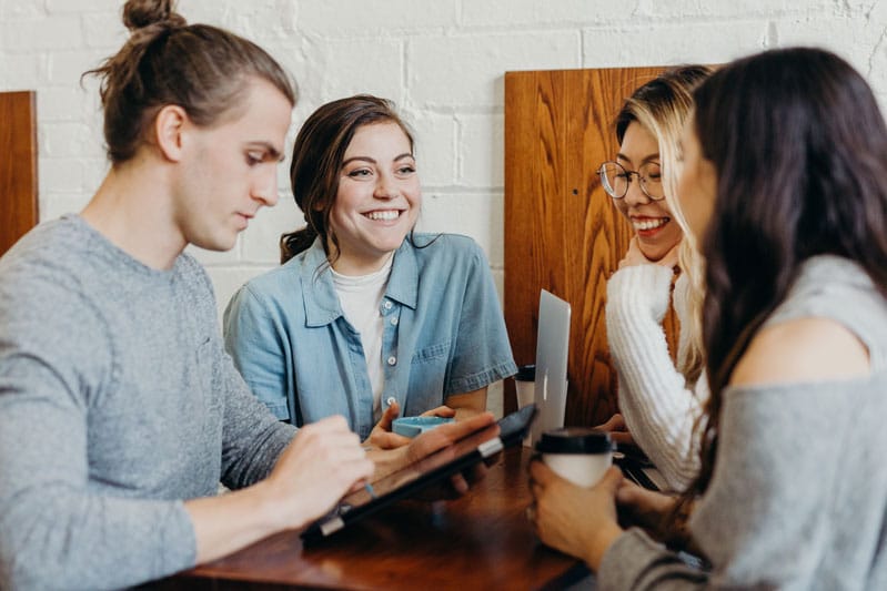 4 personnes autour d'un café, parlant de business